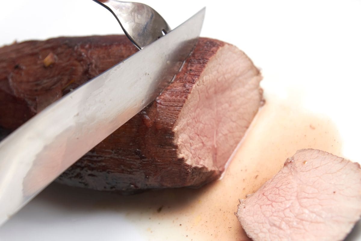 forchetta e coltello che tagliano un arrosto