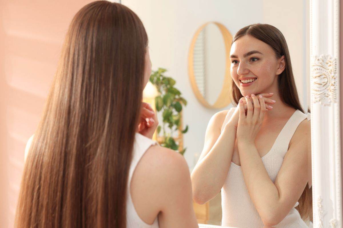 Ragazza felice si guarda allo specchio