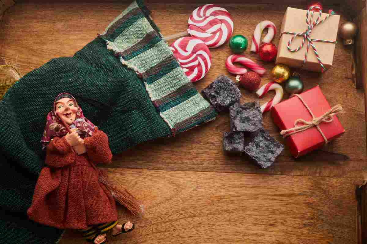 Una calza della Befana in feltro con dolciumi ed una statuina della Befana
