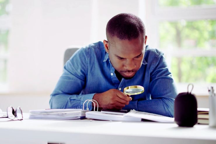 uomo con lente verifica documenti