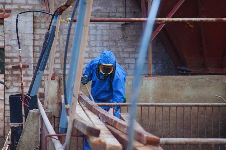 operaio con protezione su cantiere con amianto